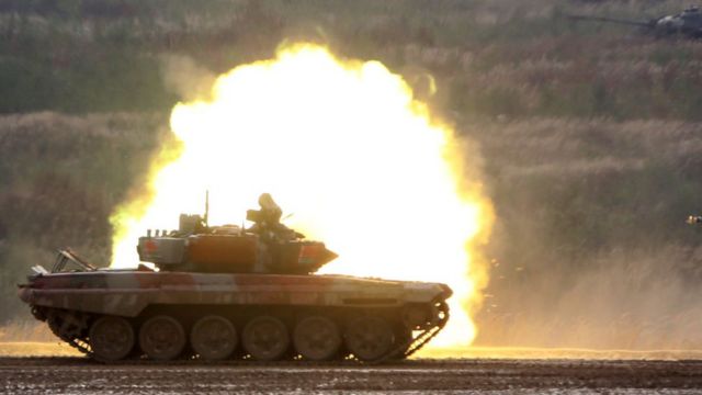 Panzer auf einem Militärgelände vor dem Hintergrund einer Explosion