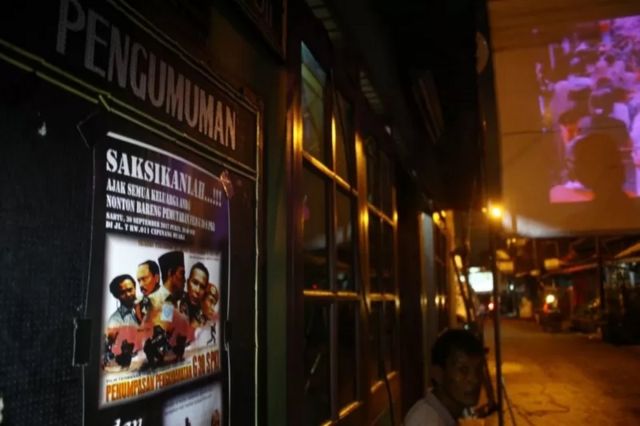 Sejumlah orang menyiapkan proyektor dan layar untuk menonton bersama film Pemberontakan G30S/PKI di Cipinang, Jakarta, 29 September 2017.