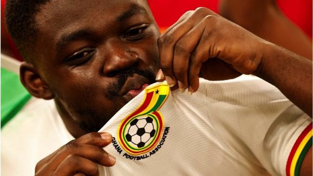 Seorang penggemar tim nasional Ghana mencium jerseynya