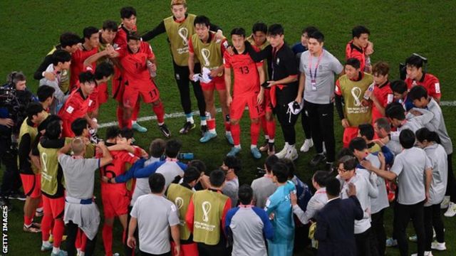 Para pemain timnas Korea Selatan berpelukan sambil menunggu hasil pertandingan antara Uruguay dan Ghana.