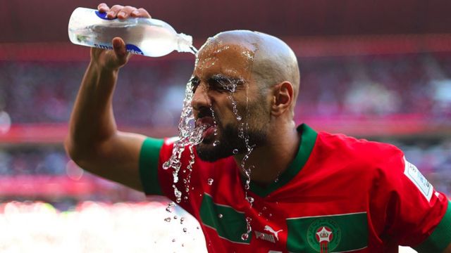 Seorang pemain Maroko menuangkan air ke wajahnya