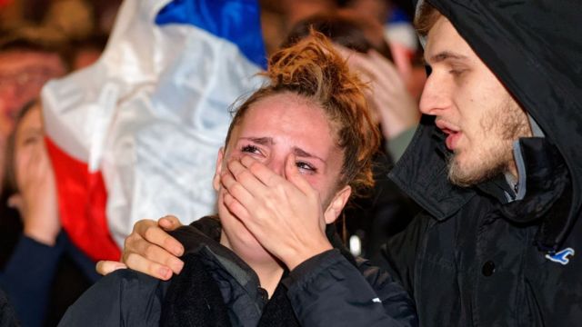Seorang pria menghibur seorang wanita setelah Prancis kalah di Piala Dunia