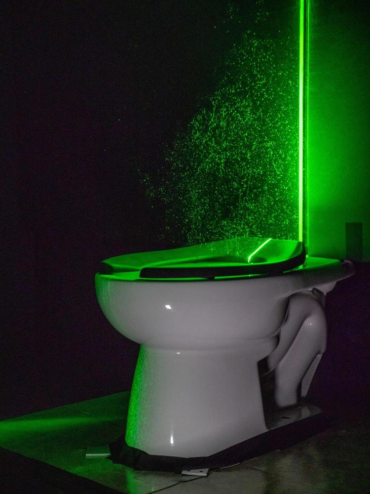 Laser hijau yang kuat membantu memvisualisasikan semprotan aerosol dari toilet 